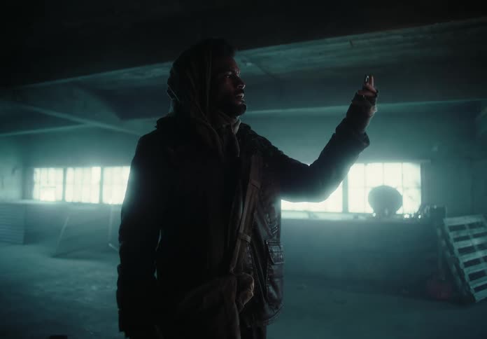 Man inside an abandoned building observing an object in his hand