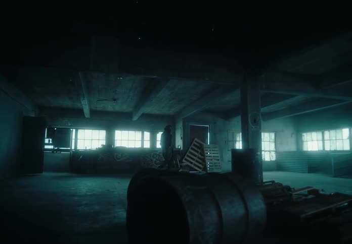 A man walks through the abandoned warehouse