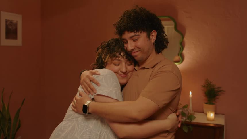 Happy couple hug each other in a cozy room