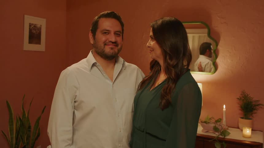 Happy couple hug and turn around to smile at the camera