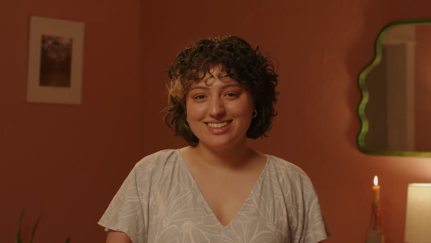 Lady smiling while standing in a room at night