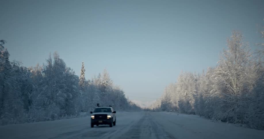 An all terrain vehicle coming down a snowy road