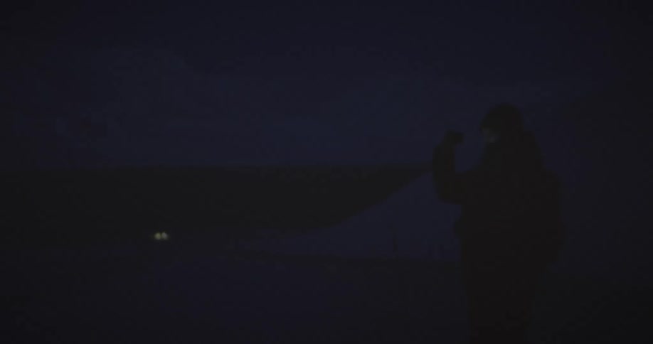 A person photographing the icy landscape at night