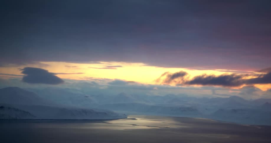 Panorama of icecovered mountains with a central sea on a day with a purple and orange dawn sky