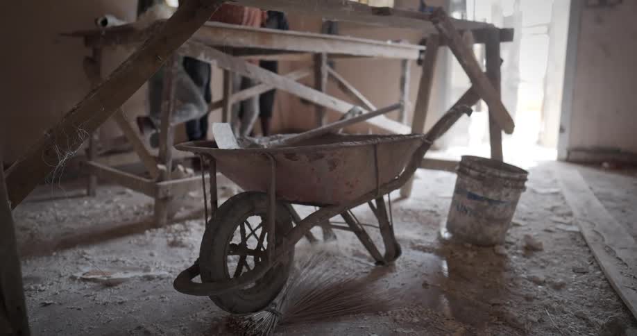 A wheelbarrow in a house under construction