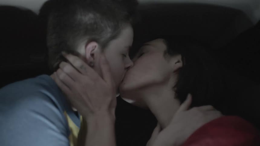 Two people kiss while the lights pulse