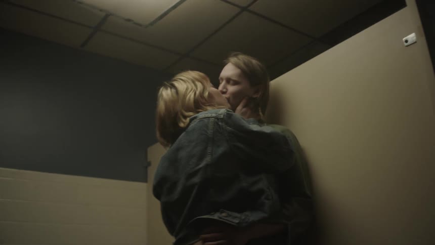 A man and woman passionately kiss in a bathroom