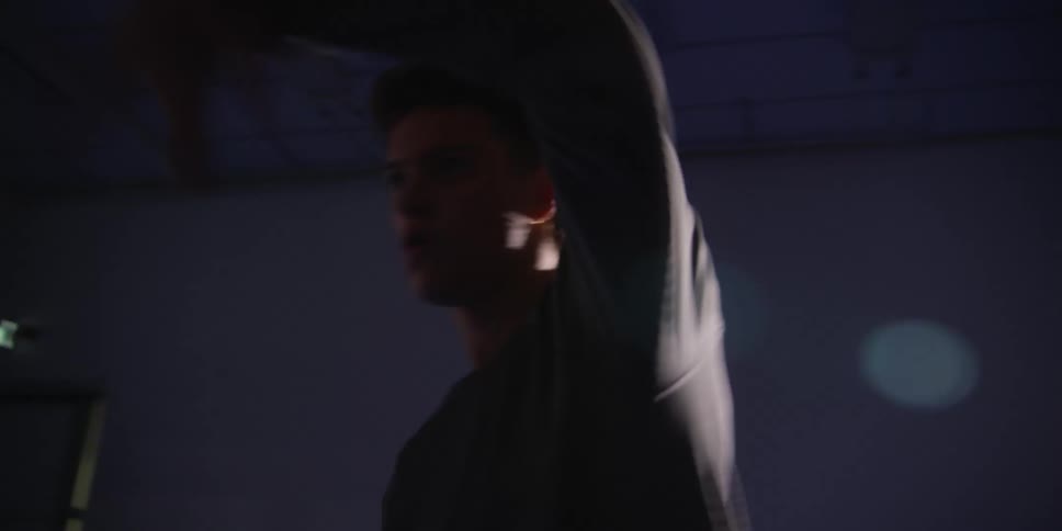 Young man dancing in a room with low lighting