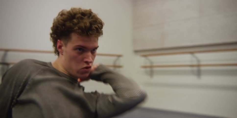 Male dancer practices dance routine in dance studio