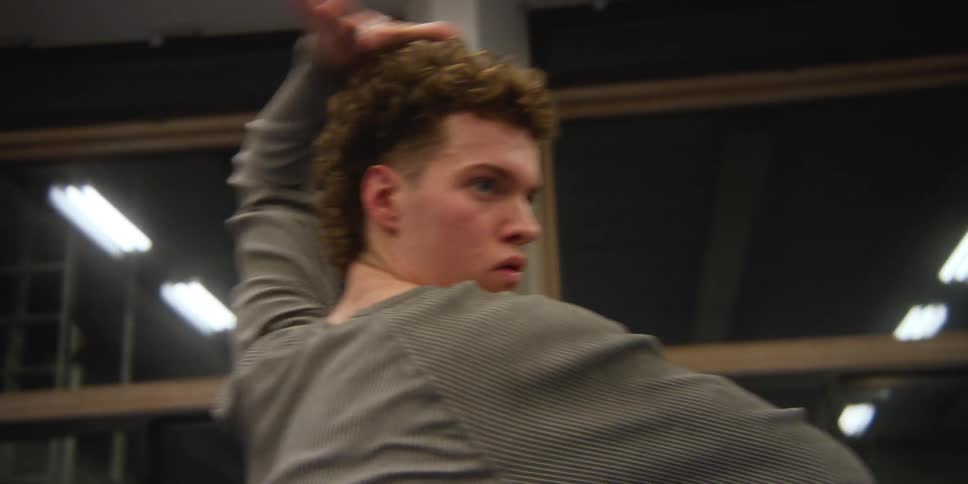 Closeup of a mans face making dance movements with his arms