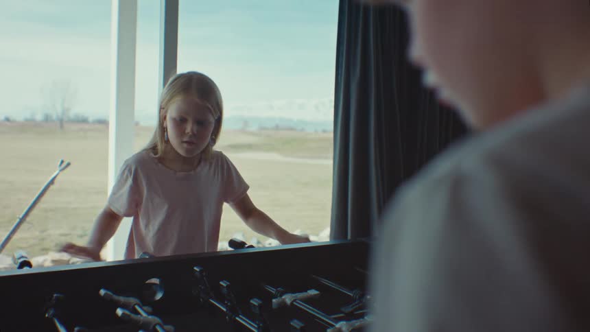 Boy and little girl playing foosball concentrated