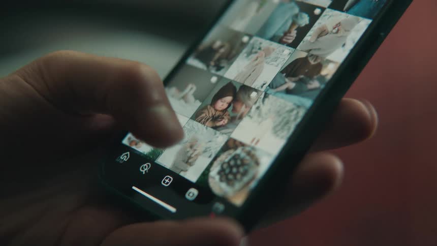 A person is flipping through the photos on their phone