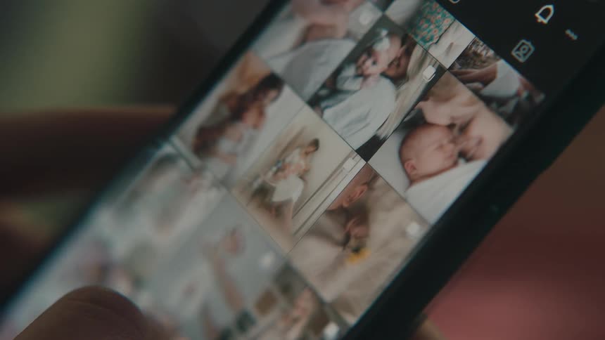Extreme close up on a finger scrolling the smartphone screen while viewing photos