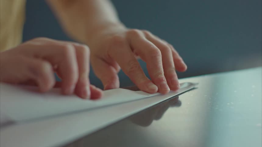 Closeup of a childs hands making a paper airplane