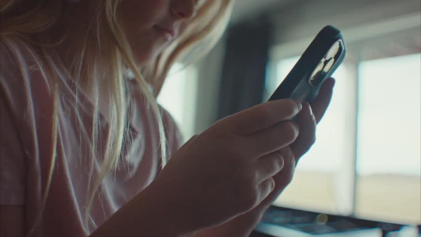 A child is using her cell phone