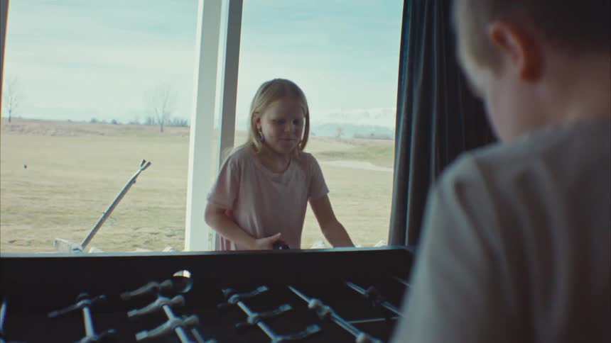 Two children play foosball together