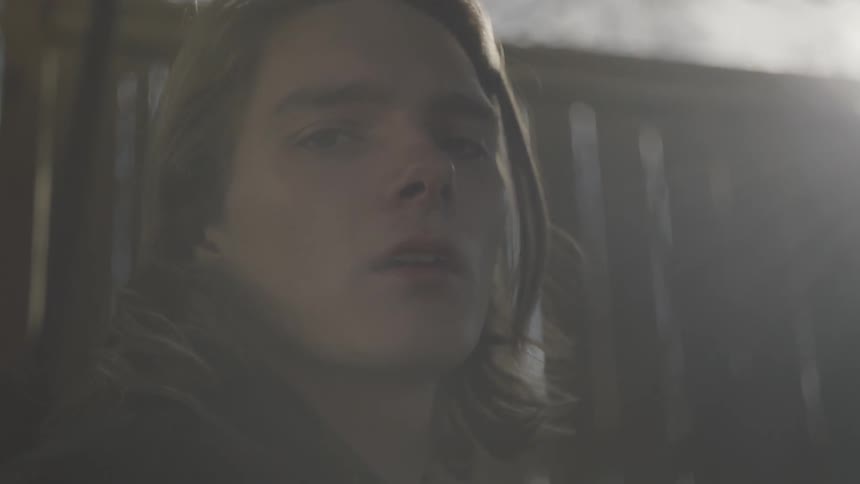 A man is standing outside looking ahead