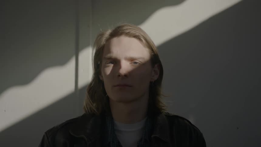 A man with longish blonde hair staring at the camera