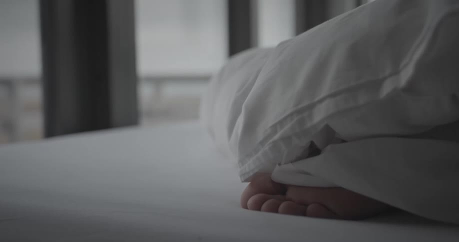Closeup of the foot of a person lying in bed