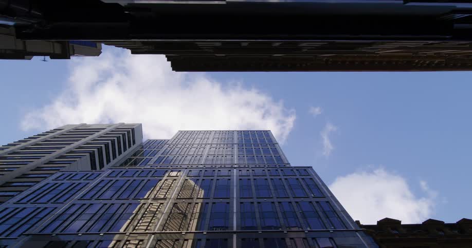 Upward view during blue sky daytime with a skyscraper in a metropolis