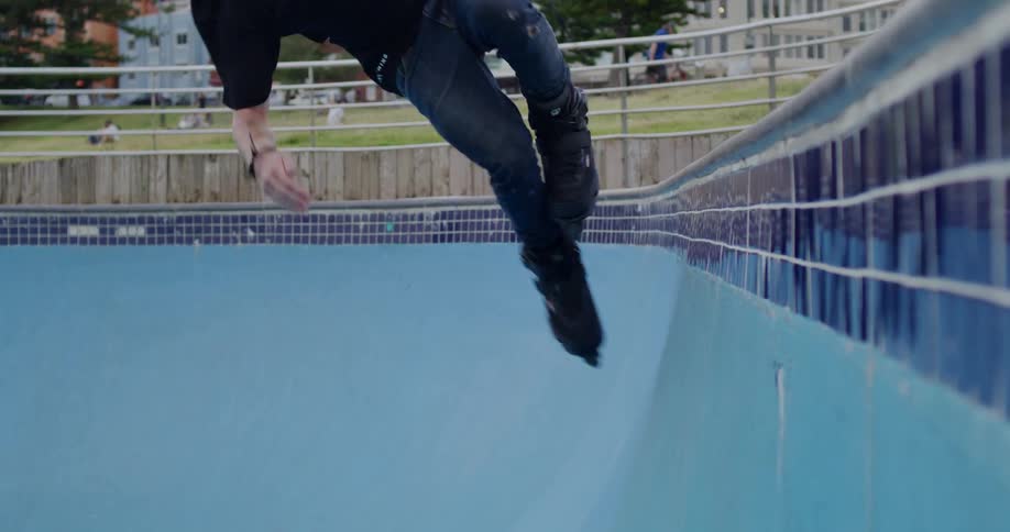 Man doing a trick on the side of a pool without water with pots