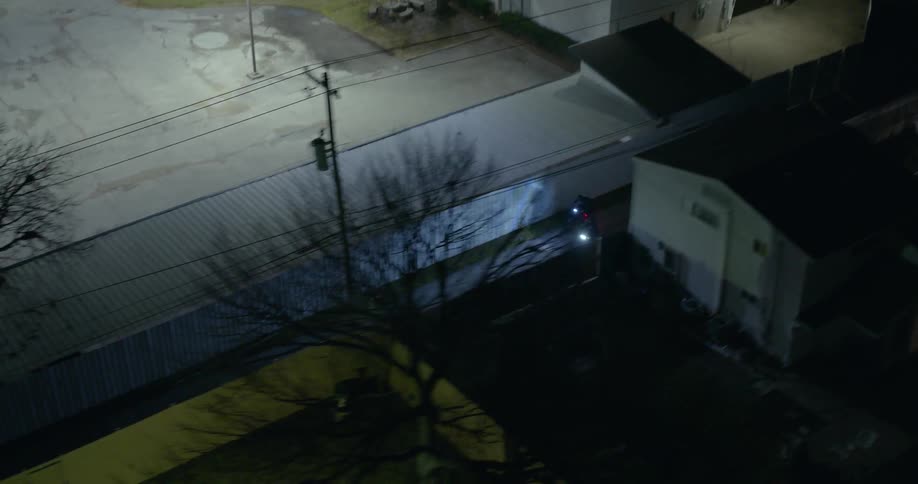 Aerial view of a couple of motorcycles driving on a street at night