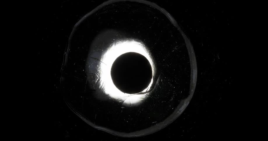 A black sphere with a circle of light around it