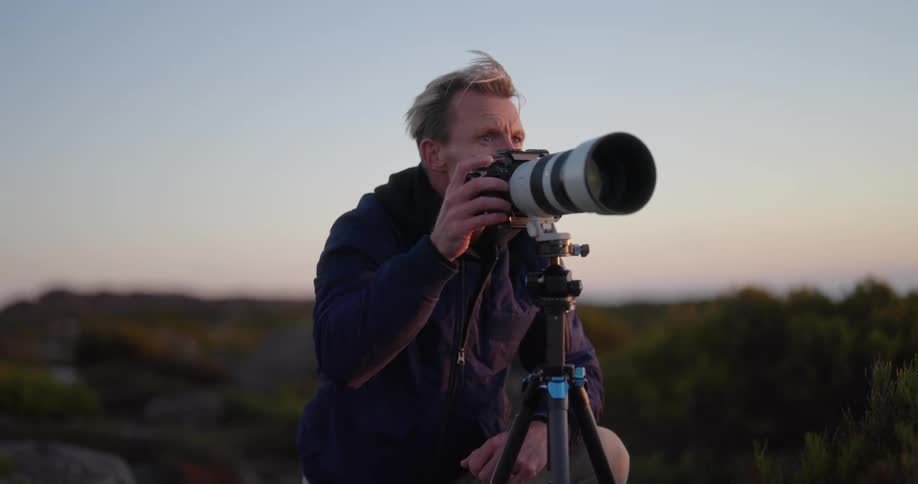 Photographer using his professional camera outdoors in nature one morning
