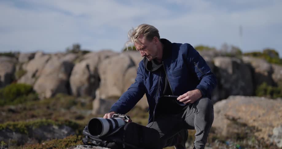 A man is adjusting his camera