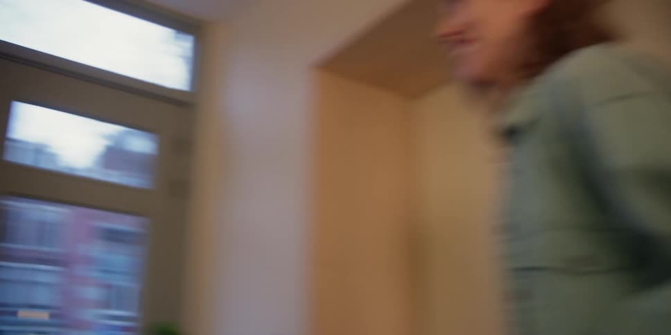 A young male dancer and adult female dance instructor laughing together after working on choreographed moves in a private studio in the city.