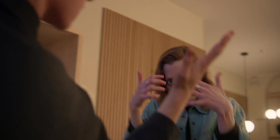 A young male dancer works on expressive arm movements as his older female instructor coaches him on technique.