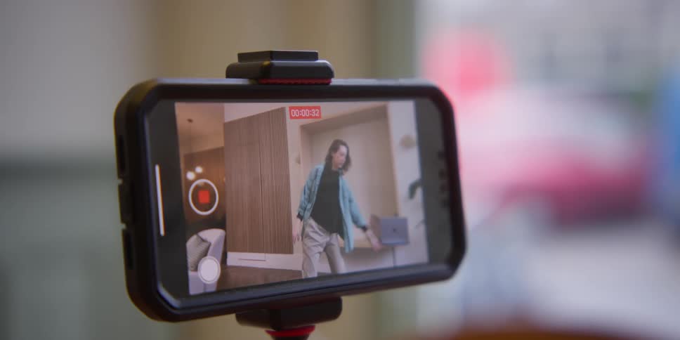 POV toward the phone camera as a woman records herself dancing and then turns the record button off.