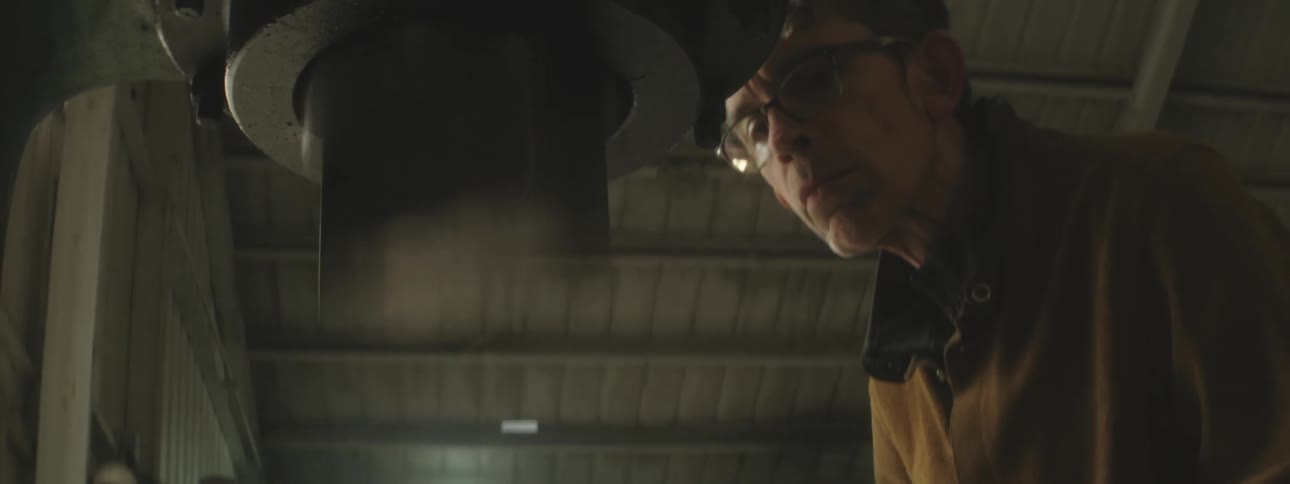 Man looking closely with goggles at a machine understanding