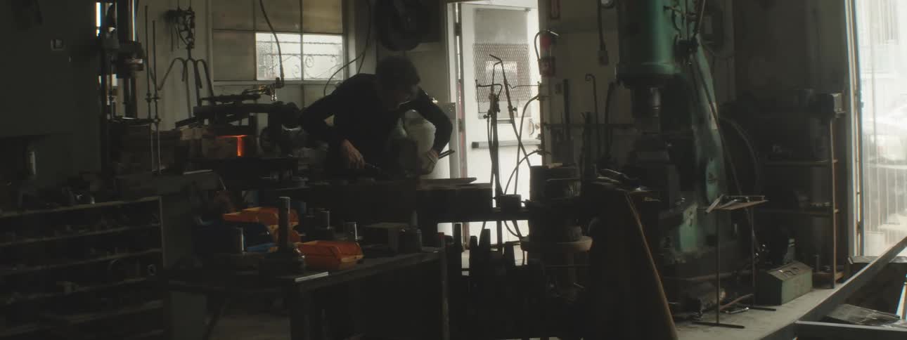 A blacksmith is working in his shop