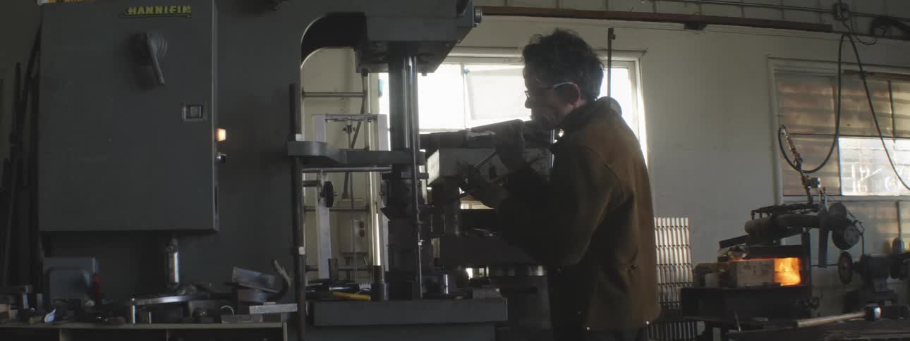 A man is using a machine in his shop