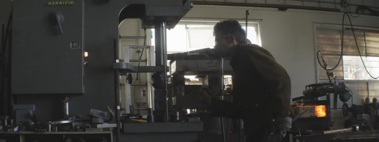 Man with the help of a hammer hammering a metal sheet
