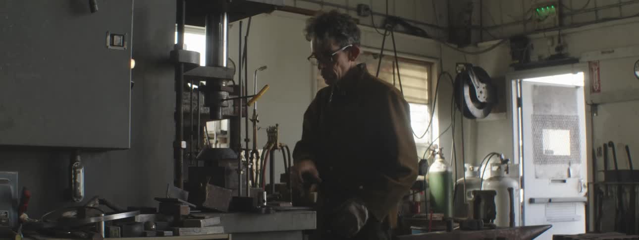 A blacksmith is working in his shop