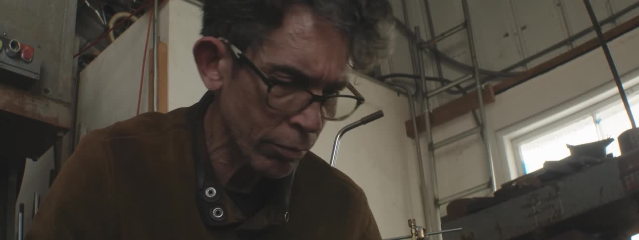 A blacksmith is hammering in his shop
