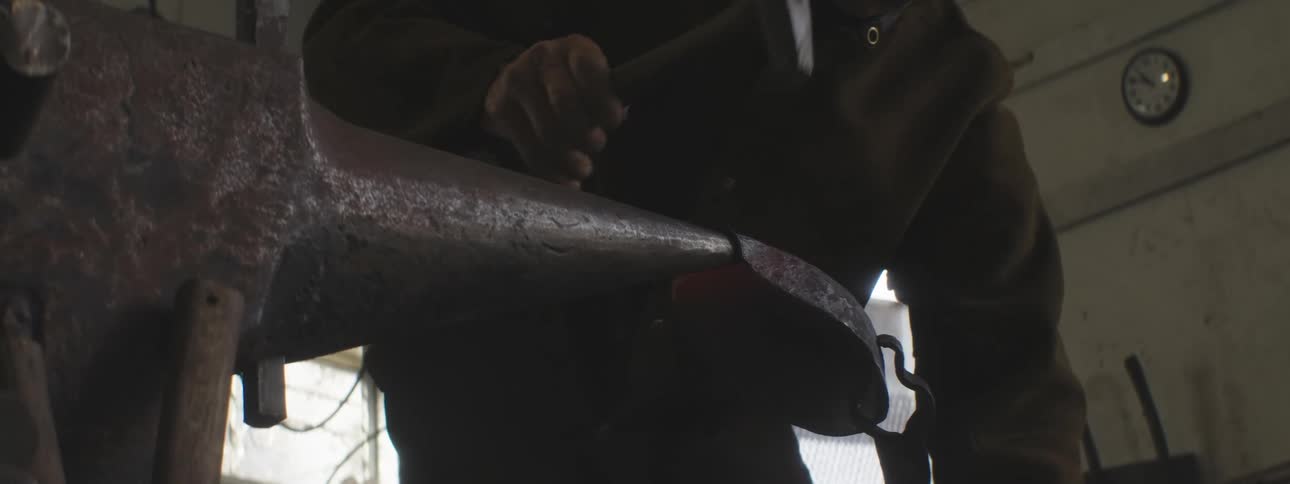 A man is hammering metal on an anvil