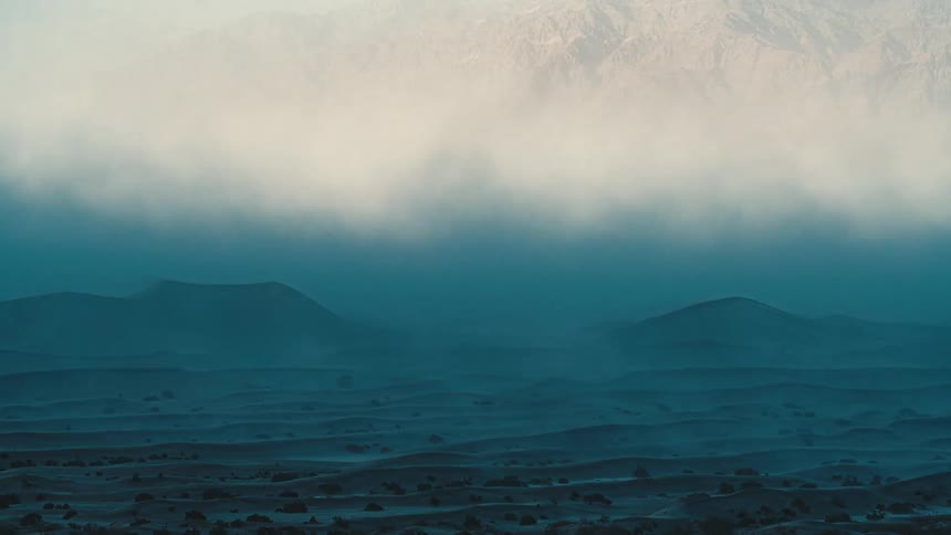 A sandstorm blowing over Mesquite dunes creating a epic scene
