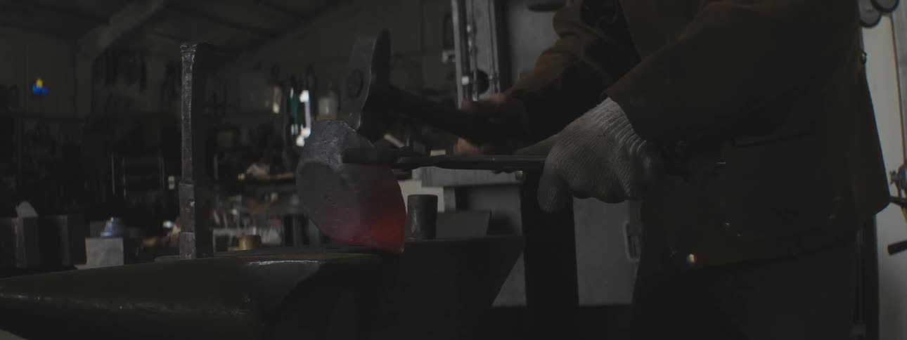 A man is hammering hot metal