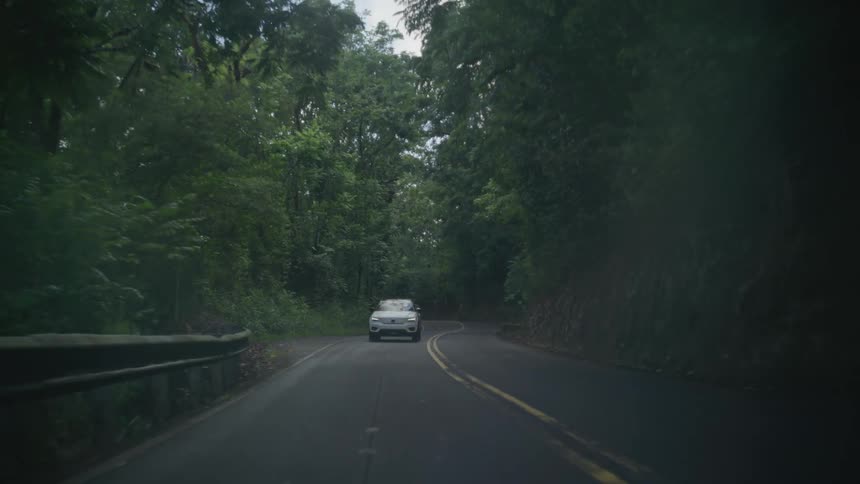 A white car drives down the road
