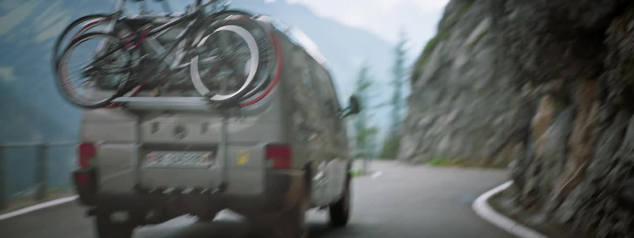A van sliding on a mountain road losing control hitting a rock and almost crashing