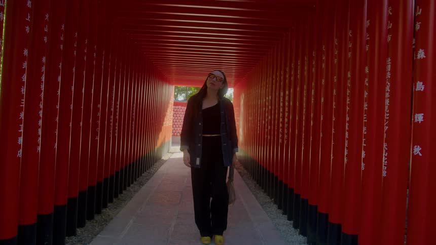 Woman crossing a tunnel with stakes in a square in japan