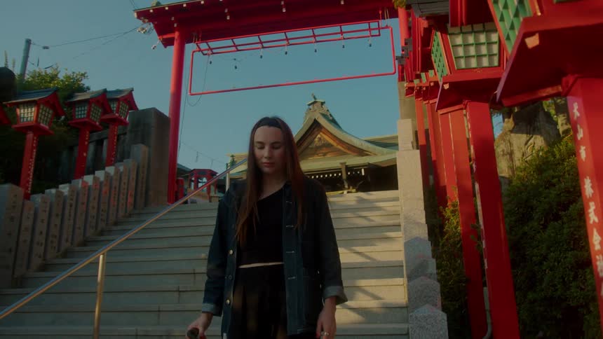 A woman walking down the steps from a chinese temple