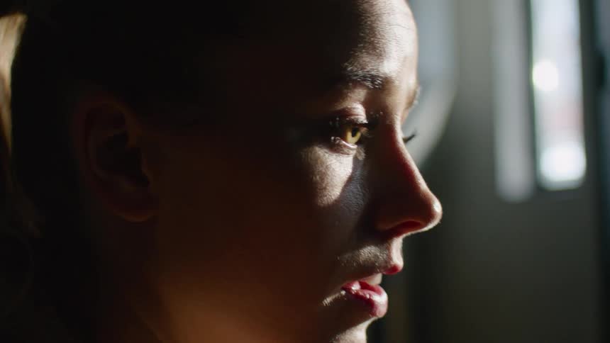 A young woman sits and thinks in a room