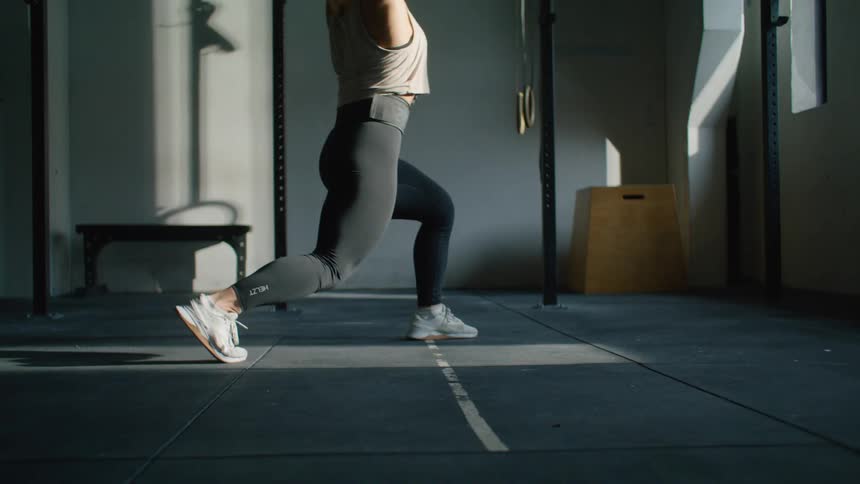 A woman is lifting a weight and drops it on the floor and then picks it back up again