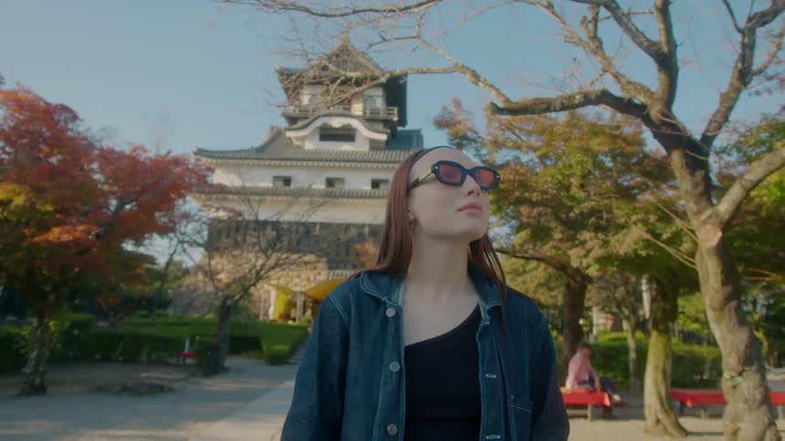 A woman looks around the garden of a chinese temple