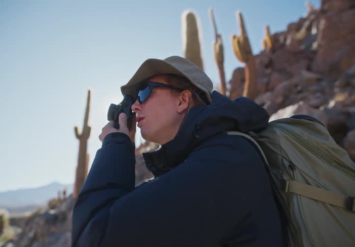 A woman photographing the deserted mountain landscape during the day