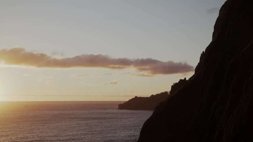Clouds float over a rocky coast